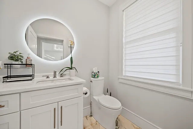 a bathroom with a toilet a sink and a mirror