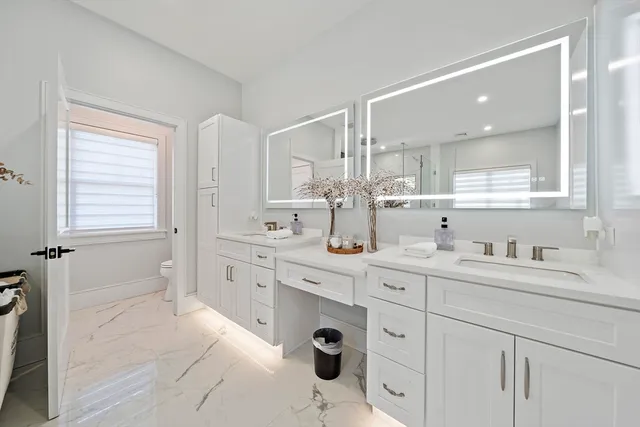 a spacious bathroom with a granite countertop sink mirror and bathtub