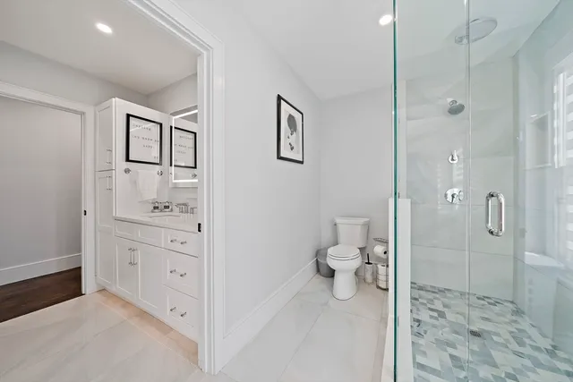 a bathroom with a sink a toilet and shower