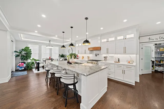 a large white kitchen with lots of counter space wooden floor and appliances