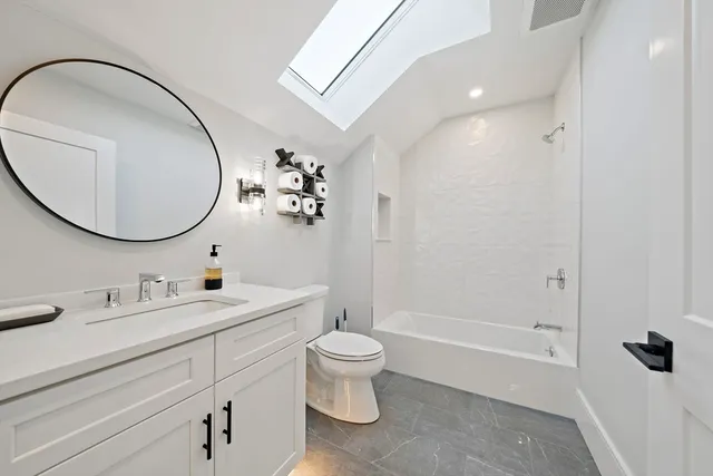 a bathroom with a toilet a sink and a mirror