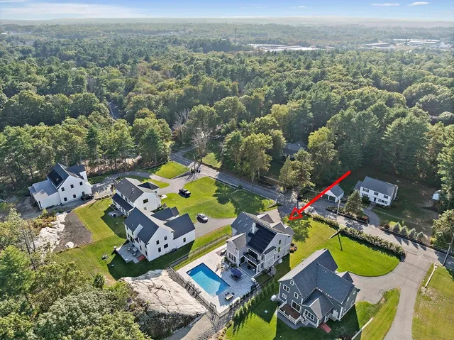 an aerial view of a house with a swimming pool a yard and mountain view