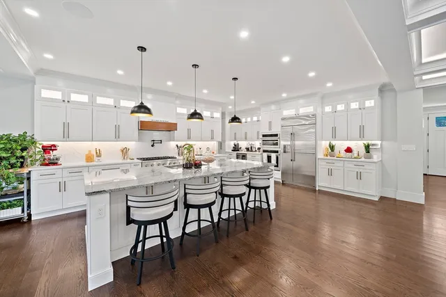 a kitchen with lots of wooden furniture appliances and white cabinets