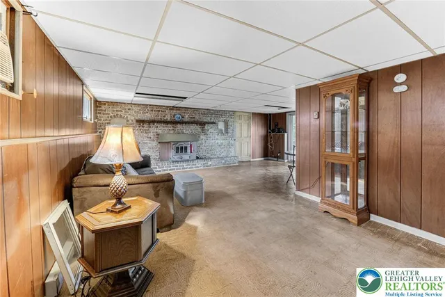 a living room with furniture a fireplace a rug and a large window