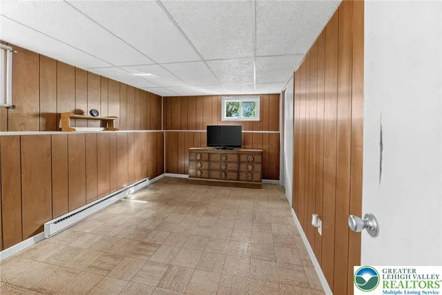 a view of a hallway to room with wooden floor and window