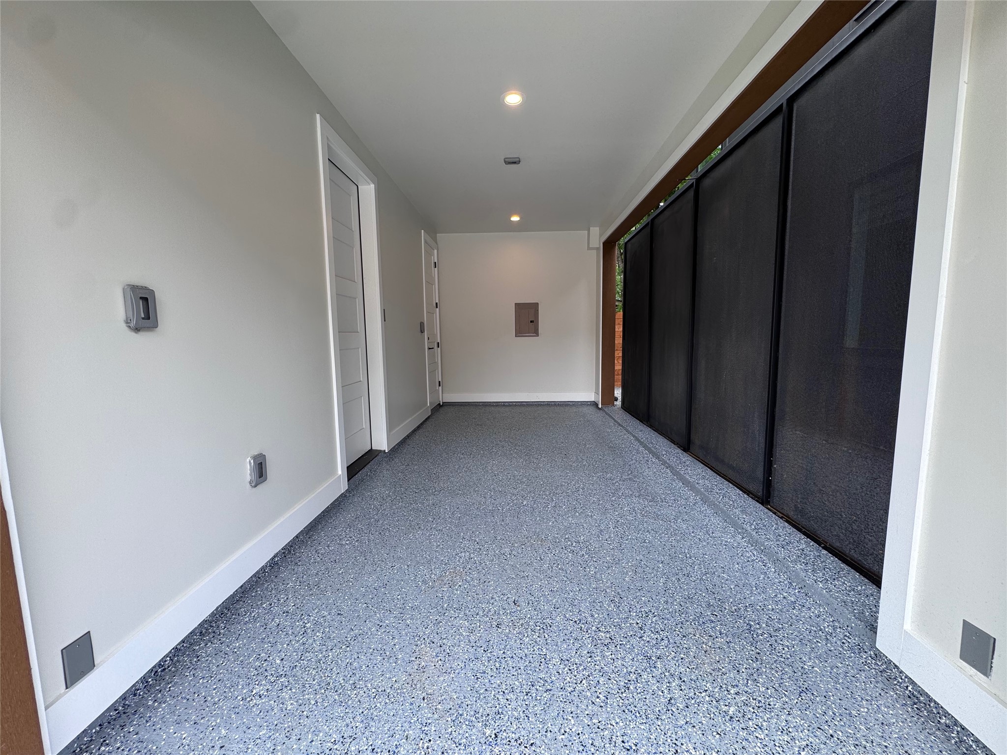 100 West Odell Street, Unit 1 Austin, TX 78752 - Photo 38 of 39 Garage space featuring an epoxy-coated floor, recessed lighting, and a roll-down mesh screen