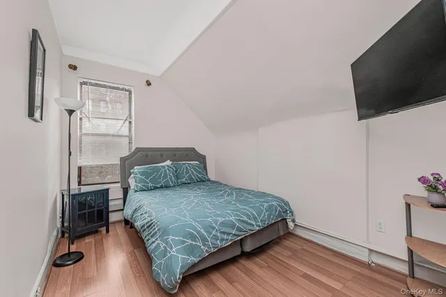 a bedroom with a bed tv and a window