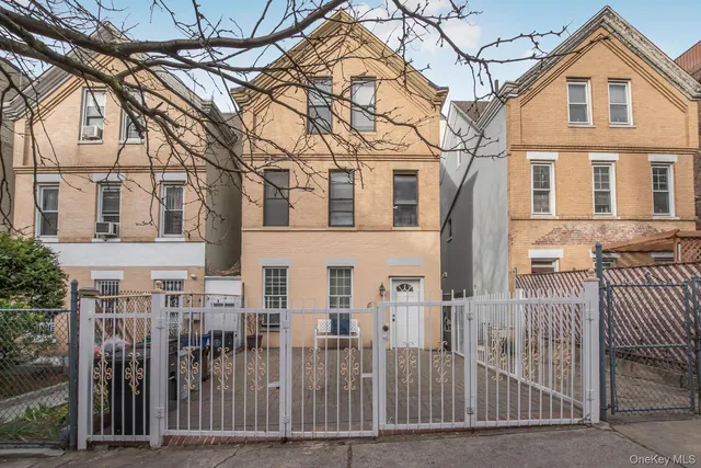 a view of a white house with iron fence