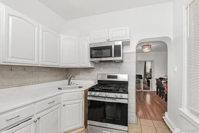 a kitchen with stainless steel appliances white cabinets and a stove top oven