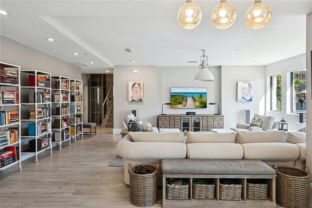 1135 3rd Avenue South, Unit 119 Naples, FL 34102 - Photo 18 of 50 a living room with furniture and a book shelf
