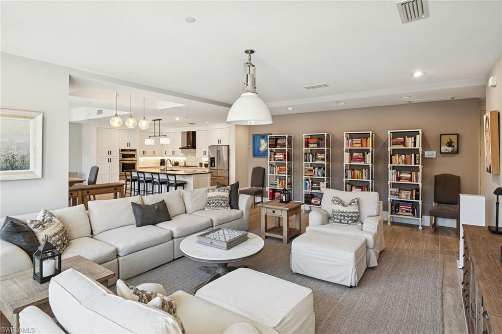 1135 3rd Avenue South, Unit 119 Naples, FL 34102 - Photo 21 of 50 a living room with furniture kitchen view and a chandelier