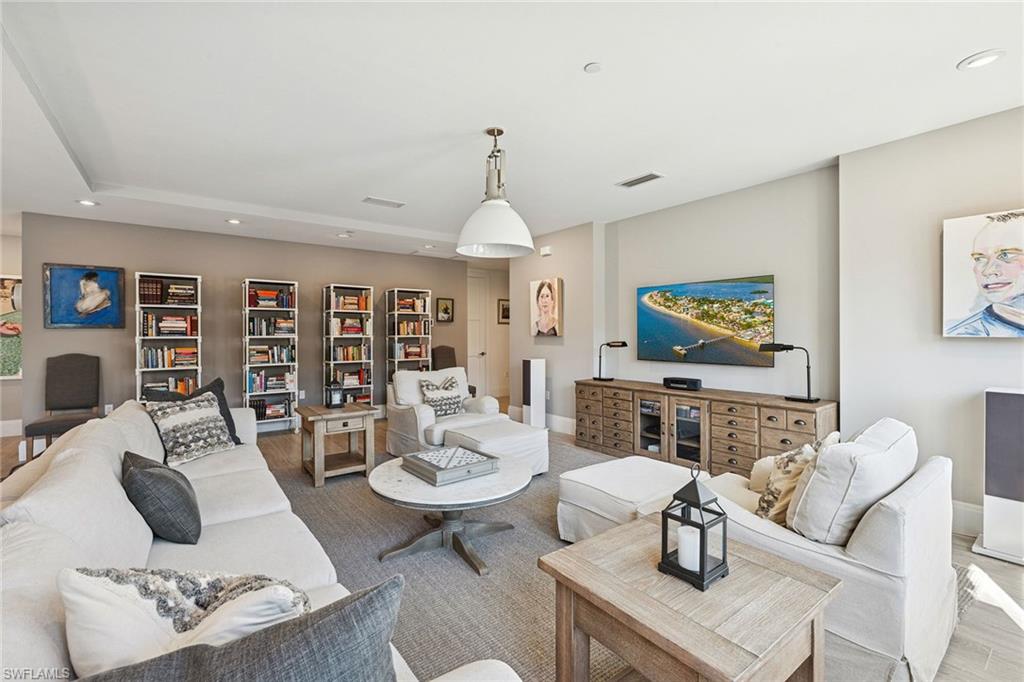 1135 3rd Avenue South, Unit 119 Naples, FL 34102 - Photo 22 of 50 a living room with furniture a rug and a flat screen tv