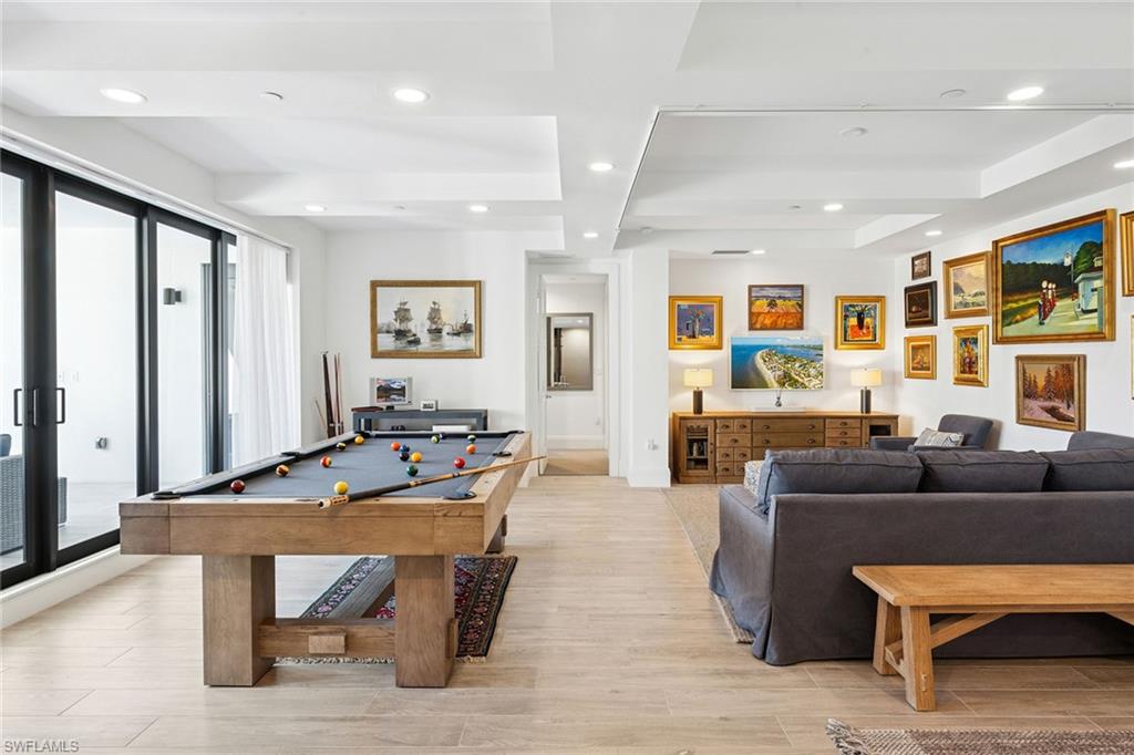 1135 3rd Avenue South, Unit 119 Naples, FL 34102 - Photo 29 of 50 a living room with furniture a table and a flat screen tv