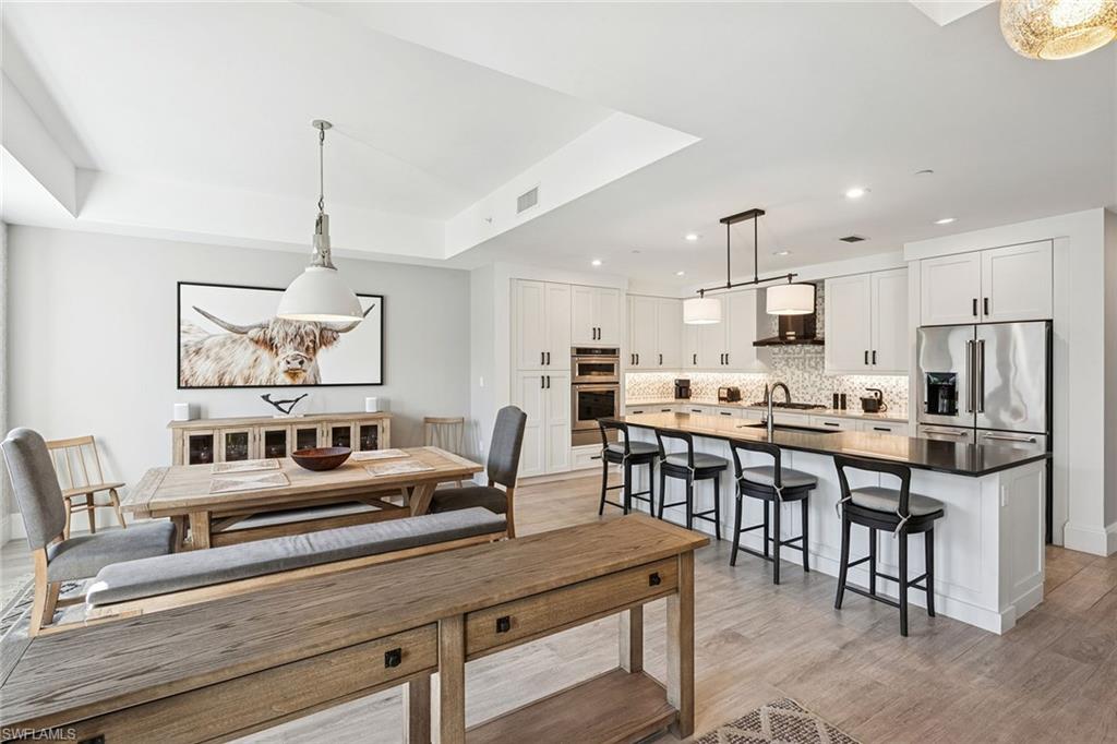 1135 3rd Avenue South, Unit 119 Naples, FL 34102 - Photo 6 of 50 a living room with stainless steel appliances kitchen island granite countertop furniture and a dining table