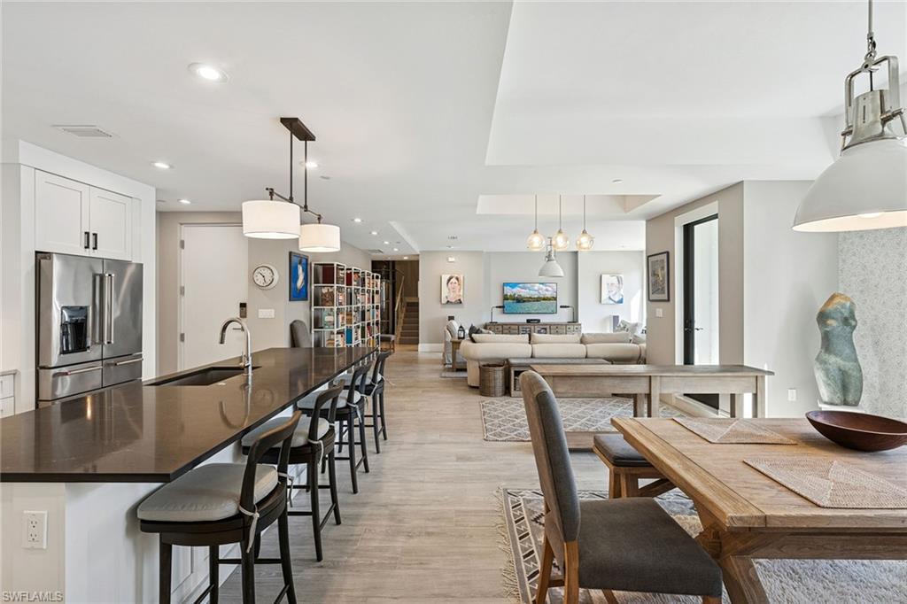 1135 3rd Avenue South, Unit 119 Naples, FL 34102 - Photo 9 of 50 a kitchen with stainless steel appliances a dining table chairs stove and refrigerator