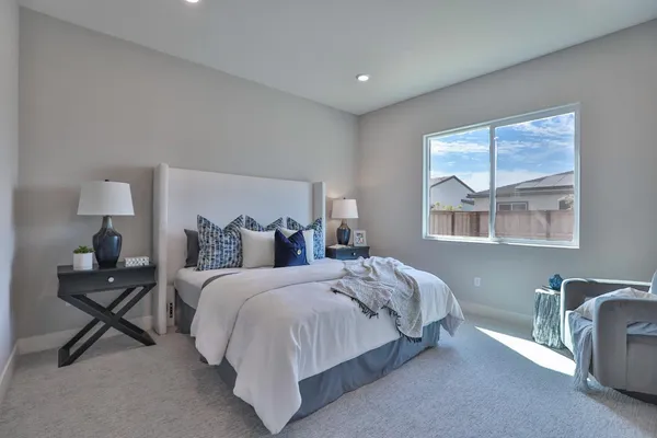 a bedroom with a bed and a large window