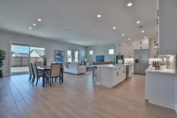a large kitchen with stainless steel appliances lots of white cabinets