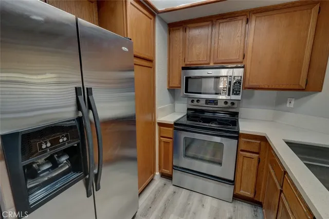 a kitchen with granite countertop a sink stainless steel appliances and cabinets