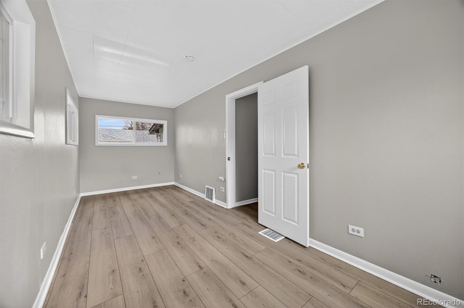 705 Perry Street Denver, CO 80204 - Photo 11 of 23 an empty room with wooden floor and windows