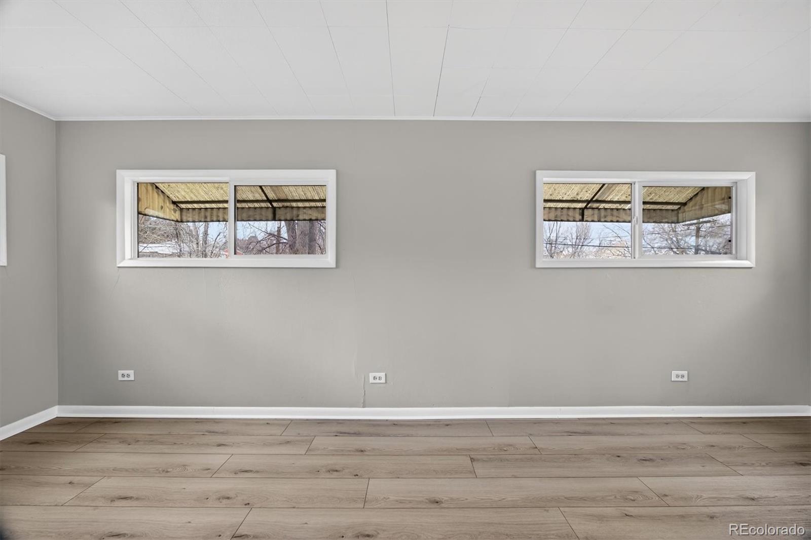 705 Perry Street Denver, CO 80204 - Photo 12 of 23 a view of an empty room with wooden floor and a window