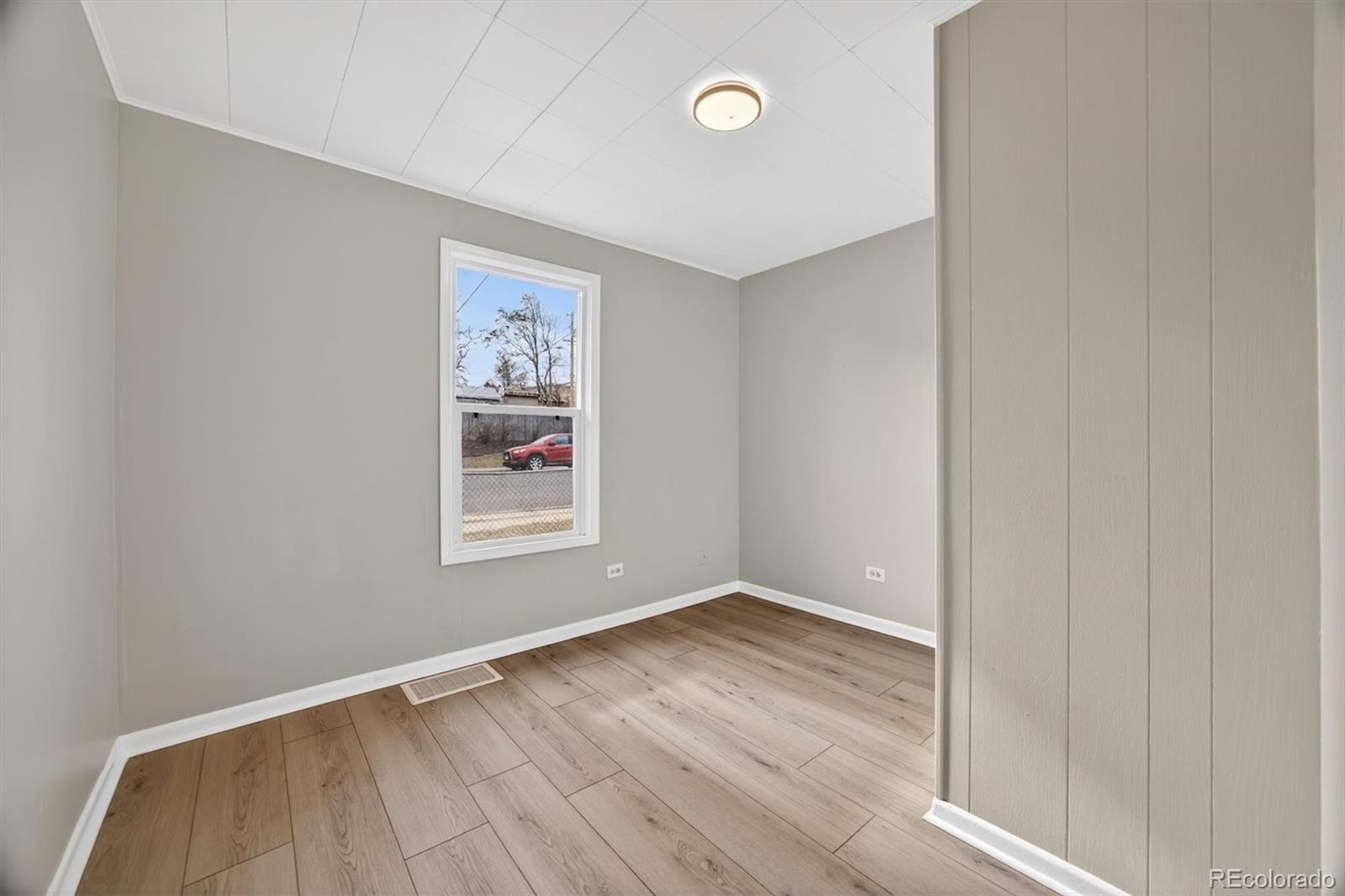 705 Perry Street Denver, CO 80204 - Photo 16 of 23 an empty room with wooden floor and windows