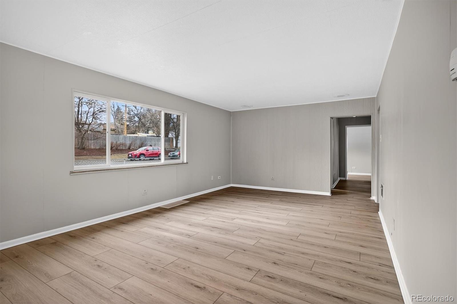 705 Perry Street Denver, CO 80204 - Photo 3 of 23 a view of an empty room with wooden floor and a window