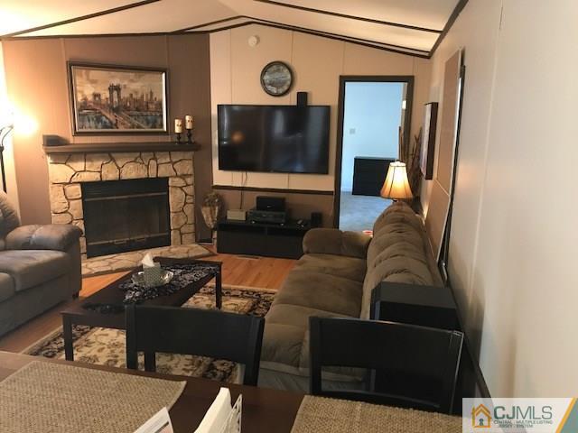 20 Burns Road, Unit 20 North Brunswick, NJ 08902 - Photo 12 of 18 a living room with furniture a fireplace and a flat screen tv
