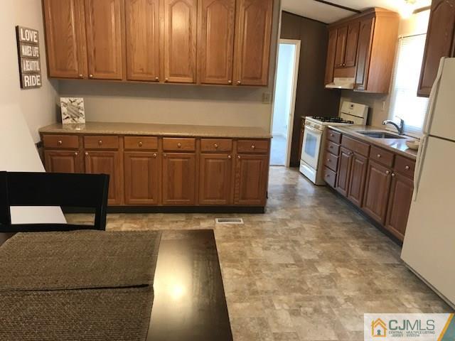 20 Burns Road, Unit 20 North Brunswick, NJ 08902 - Photo 4 of 18 a kitchen with stainless steel appliances granite countertop a stove a sink and a microwave