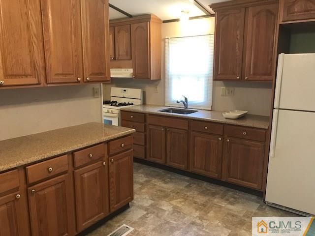 20 Burns Road, Unit 20 North Brunswick, NJ 08902 - Photo 5 of 18 a kitchen with stainless steel appliances granite countertop a sink stove and refrigerator