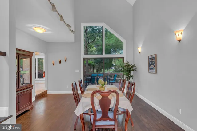 a view of a hallway with wooden floor and dining room