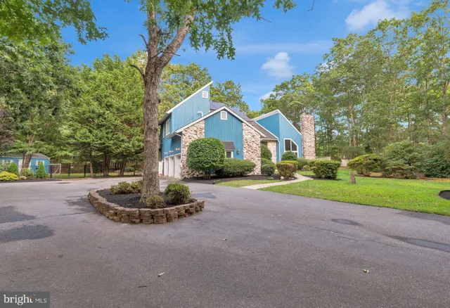 a view of a house with a yard and large tree