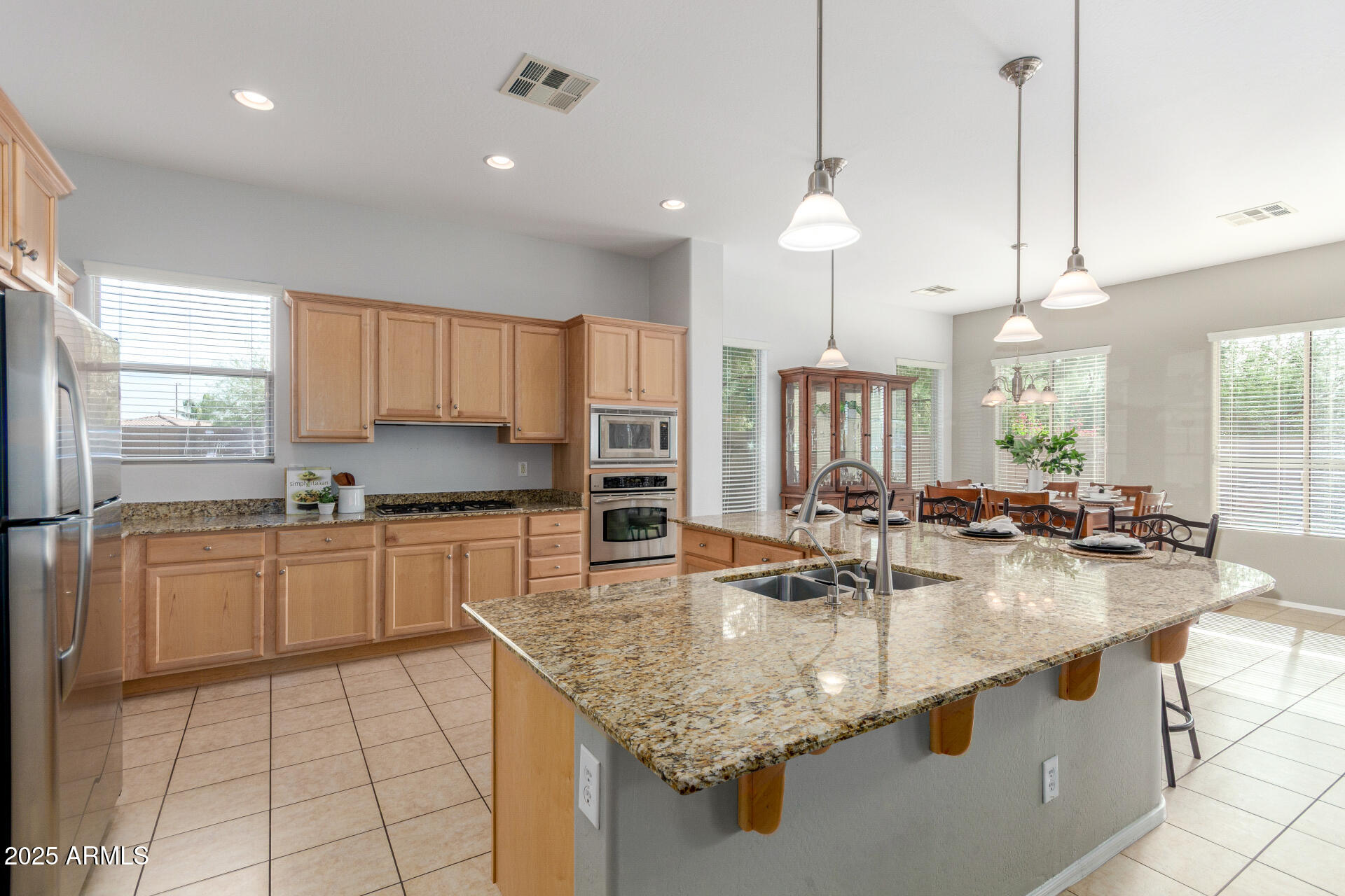 4553 East Narrowleaf Drive Gilbert, AZ 85298 - Photo 9 of 60 a kitchen with stainless steel appliances granite countertop a sink a stove and a refrigerator