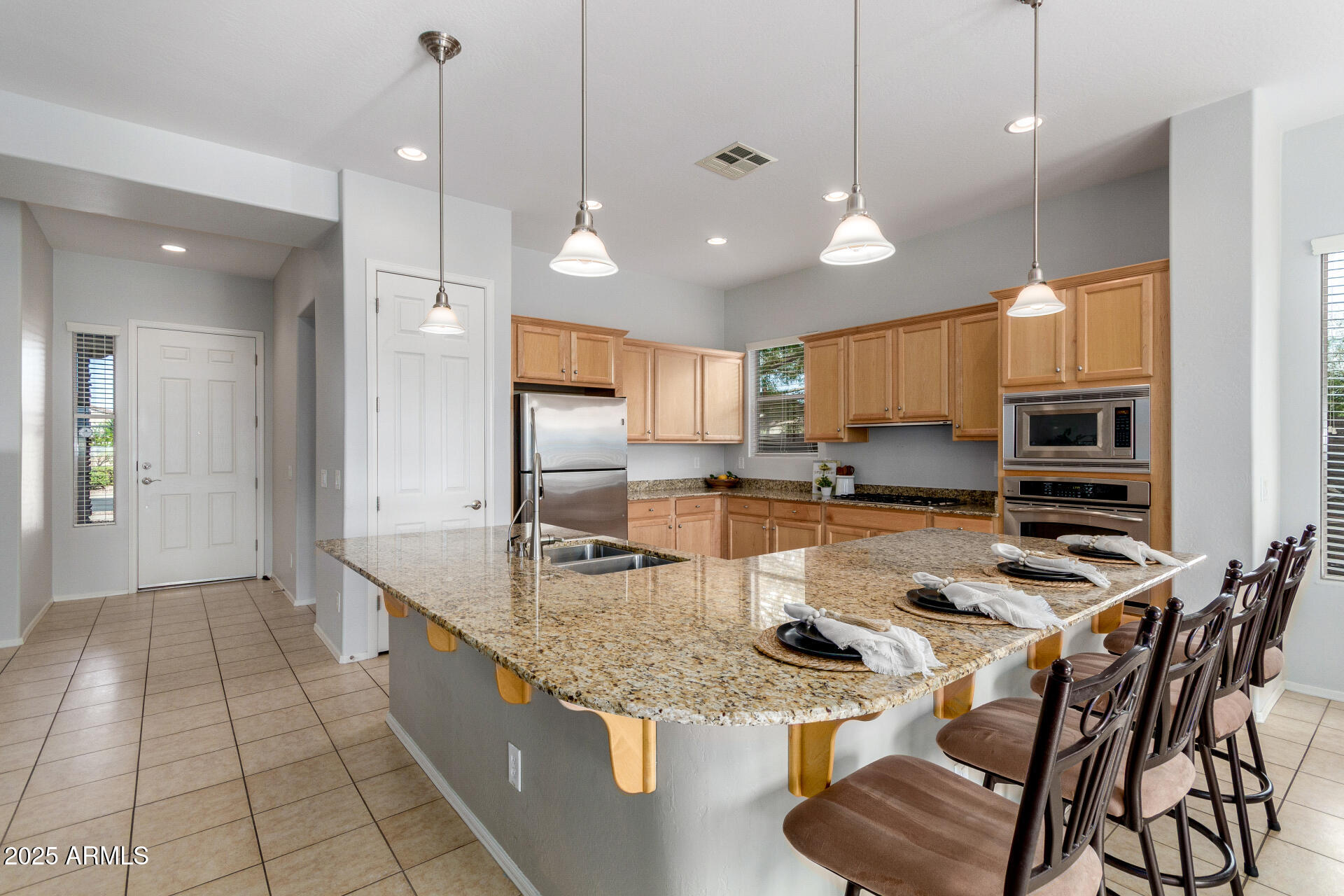 4553 East Narrowleaf Drive Gilbert, AZ 85298 - Photo 8 of 60 a kitchen with stainless steel appliances granite countertop a sink a stove a refrigerator and chairs