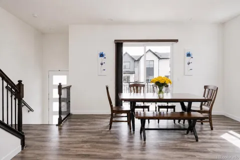 a dining room with furniture and wooden floor