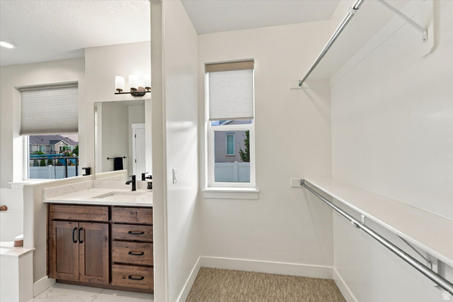 754 West 400 North Mapleton, UT 84664 - Photo 32 of 86 Custom vanity with integrated sink, matte black fixtures, and mirror. Double walk in closets.