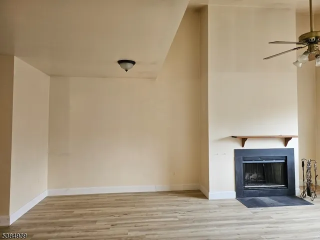 a view of a livingroom with wooden floor and a fireplace
