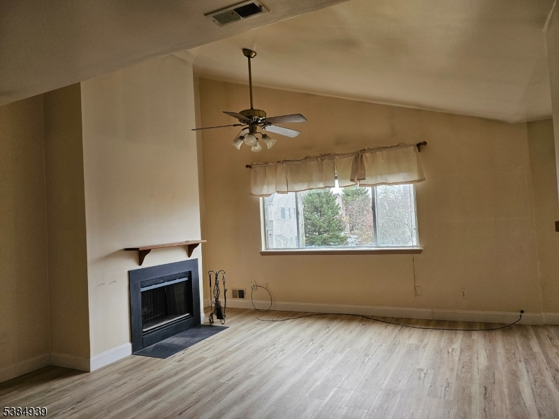 78 Falcon Ridge Way North, Unit 8 Hamburg, NJ 07419 - Photo 7 of 14 a view of empty room with wooden floor fireplace and fan