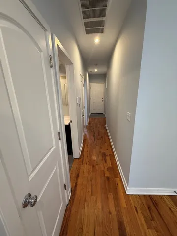 a view of a hallway with wooden floor and staircase