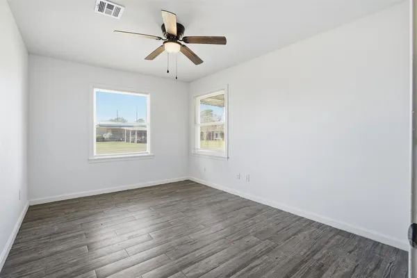 a view of room with hardwood floor and ceiling fan