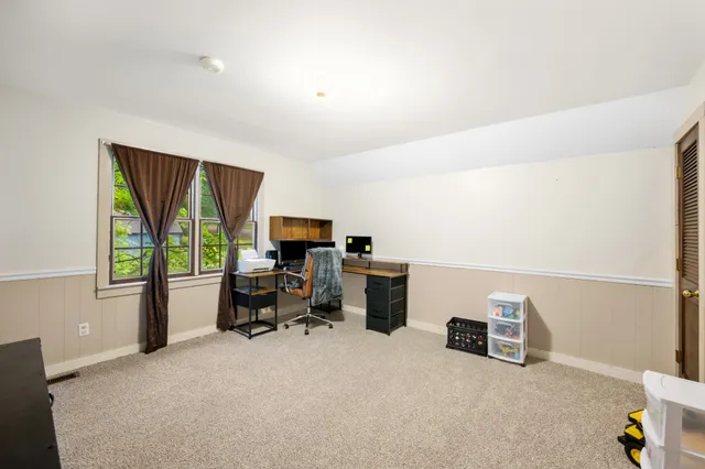a view of a workspace with furniture and a window
