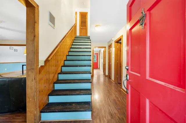 a view of staircase with wooden floor and white walls