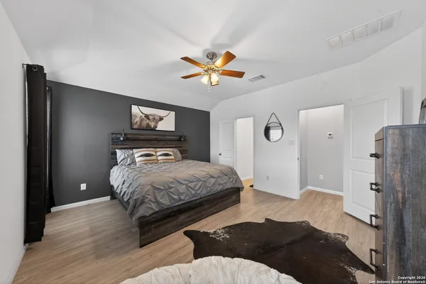 a spacious bedroom with a bed and a chandelier