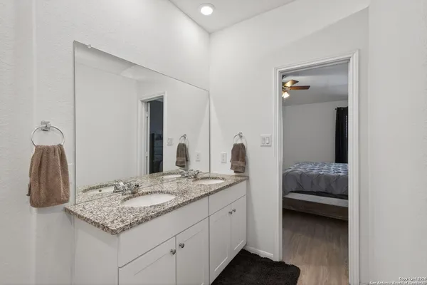 a en suite bathroom with a granite countertop sink and a mirror