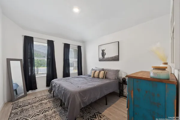 a bedroom with a bed and a dresser next to a window