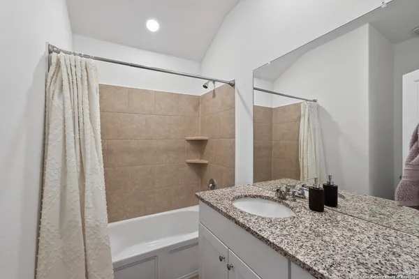 a bathroom with a granite countertop sink and a mirror