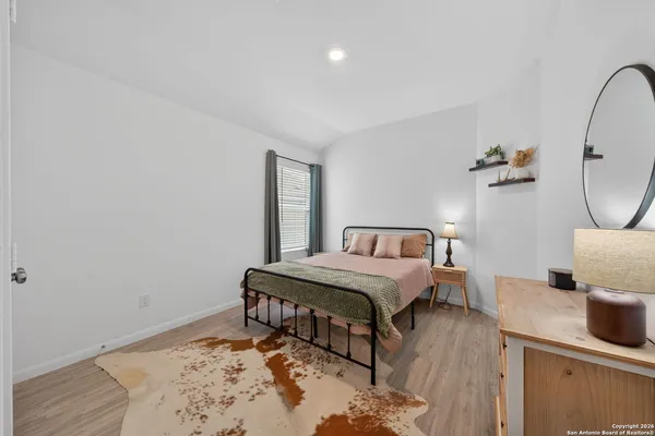 a bedroom with a bed and wooden floor