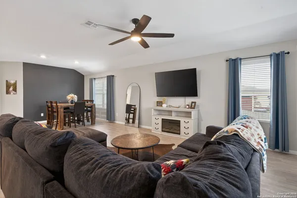 a living room with furniture a fireplace and a flat screen tv