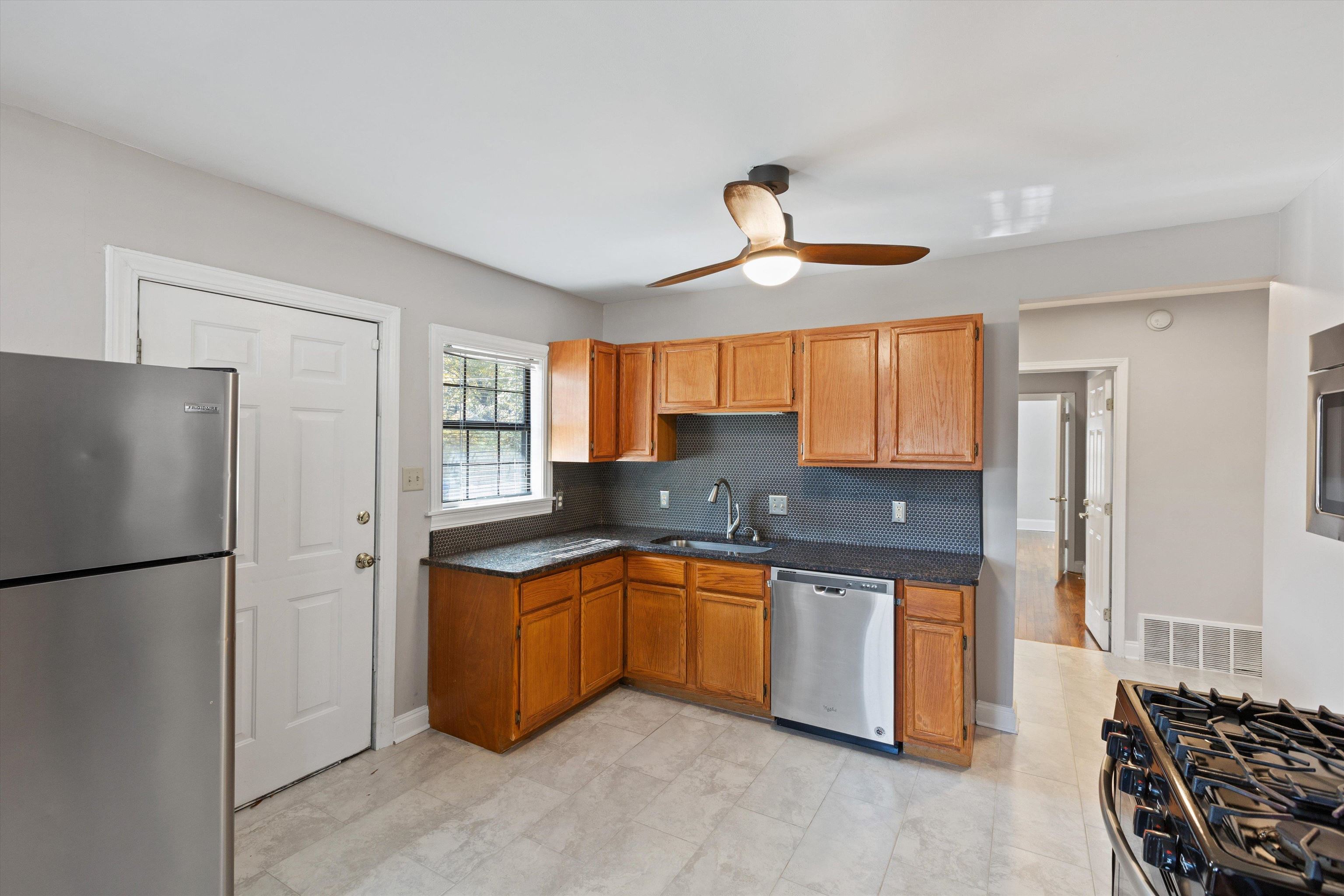 1011 Philadelphia Street Memphis, TN 38104 - Photo 12 of 26 a kitchen with stainless steel appliances granite countertop a sink a stove and a refrigerator