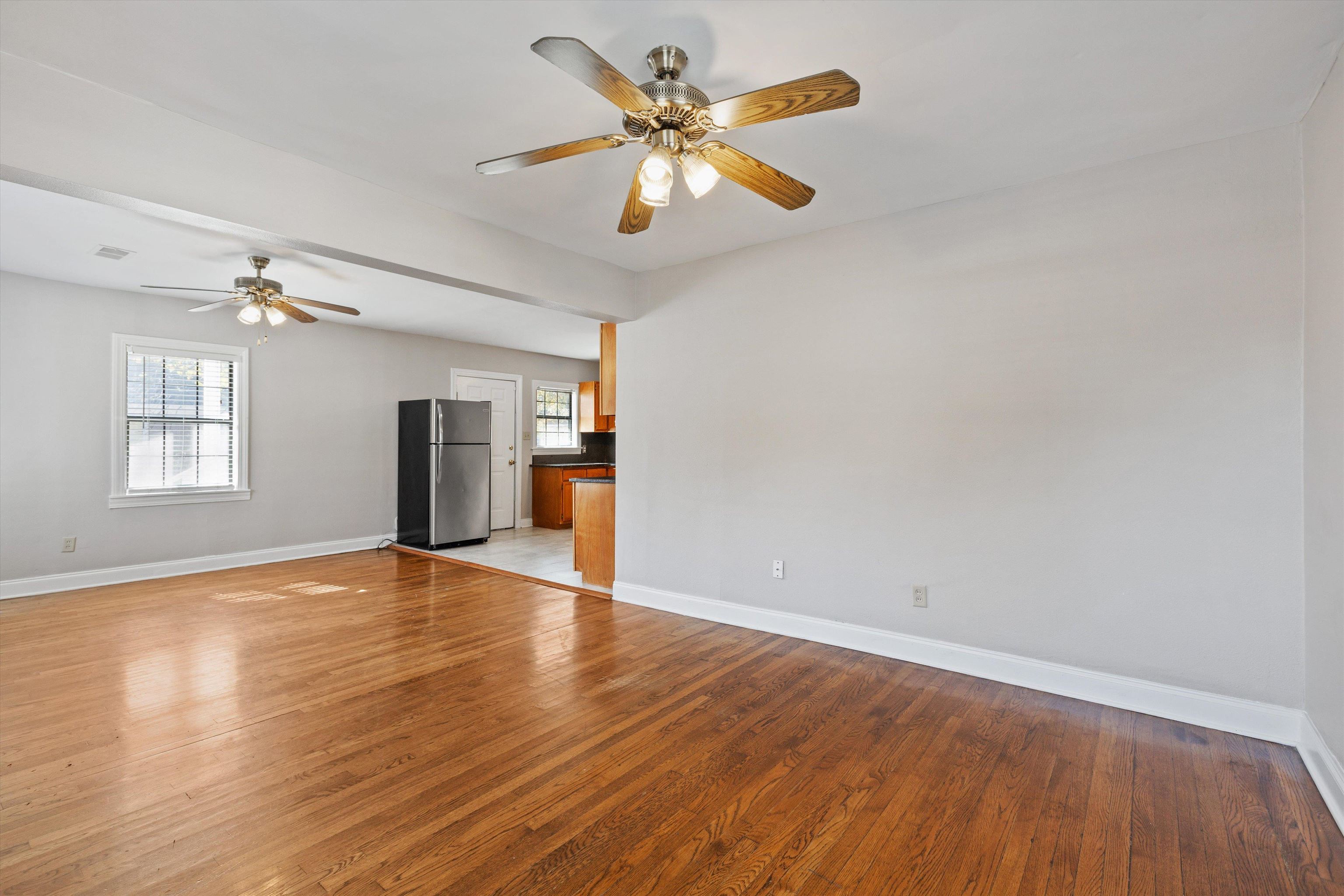 1011 Philadelphia Street Memphis, TN 38104 - Photo 7 of 26 an empty room with wooden floor chandelier fan and windows