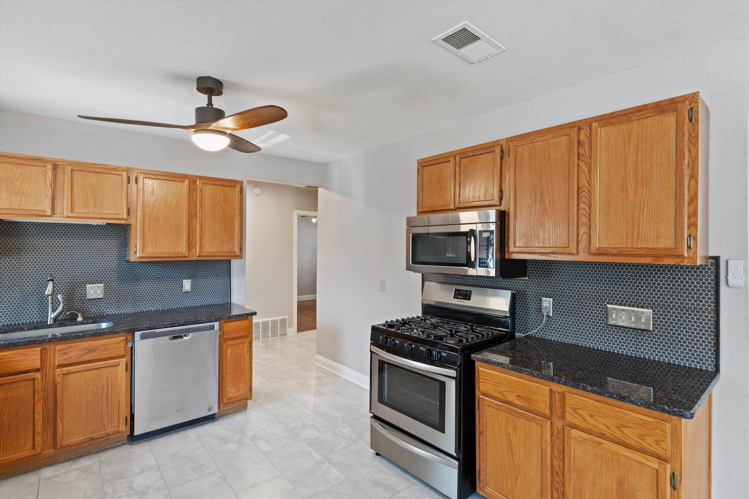1011 Philadelphia Street Memphis, TN 38104 - Photo 10 of 26 a kitchen with stainless steel appliances granite countertop a stove a sink and a microwave